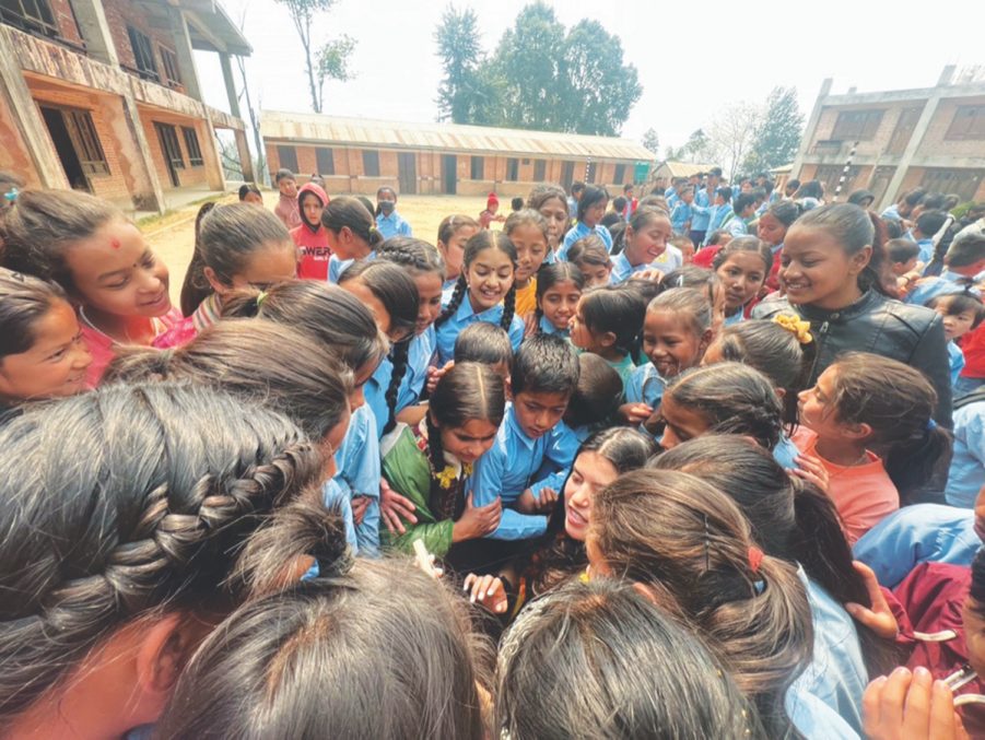 Abigail Ramos, miembro del equipo de La Sierra Enactus, muestra un video de un océano a jóvenes estudiantes nepalíes.