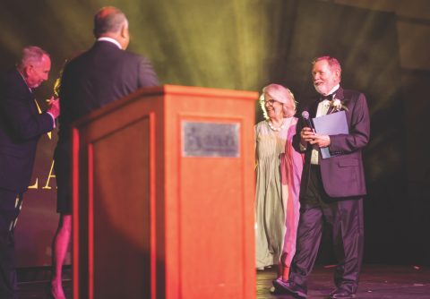 <p>Gillian and Larry Geraty, right, walk to the podium to receive the Lifetime Achievement Award from John Thomas. State Senator Richard Roth, left, and Cindy Roth (not pictured) applaud.</p><p>Gillian y Larry Geraty, a la derecha, caminan hacia el podio para recibir el Lifetime Achievement Award de manos de John Thomas. El senador estatal Richard Roth, a la izquierda, aplaude.</p>