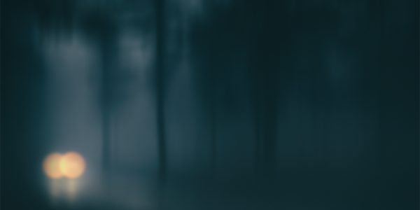car in a country road with fog and low visibility. Blur added