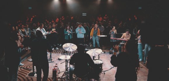 <p>Young adults gather around the praise team for worship. </p><p>Los jóvenes se unen al canto con el grupo de alabanza.