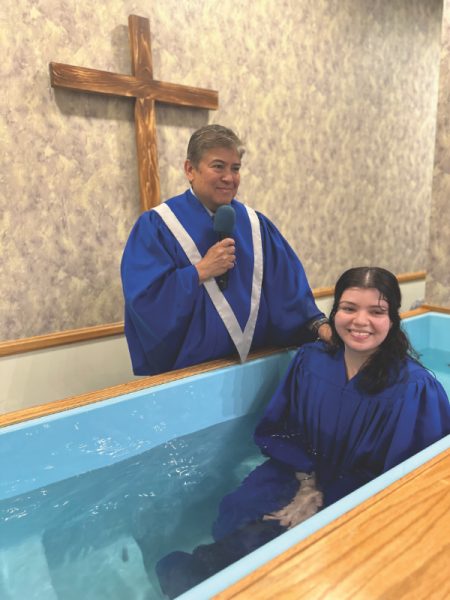 Pastor Anderson prepares to baptize Jocelyn, a 
young adult introduced to the church through friendship evangelism.