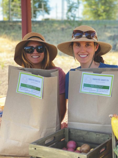 Sabrina Giese y Leah Page se ofrecen como voluntarias para dirigir el puesto de la granja.