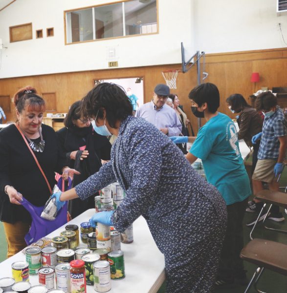 Los visitantes eligen entre una variedad de artículos en la despensa de alimentos ubicada en el gimnasio de la iglesia Whittier. 