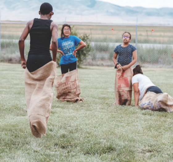 Pathfinders from the West Jordan church jump high during the potato sack race.