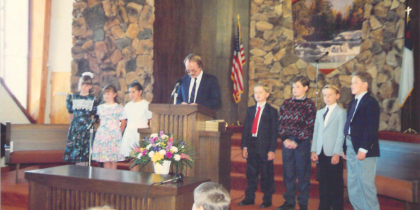 Fred Kinsey presenta Biblias a estudiantes recién bautizados, incluyendo a sus dos hijos. Él creía que la educación adventista era un ministerio importante de la iglesia.
