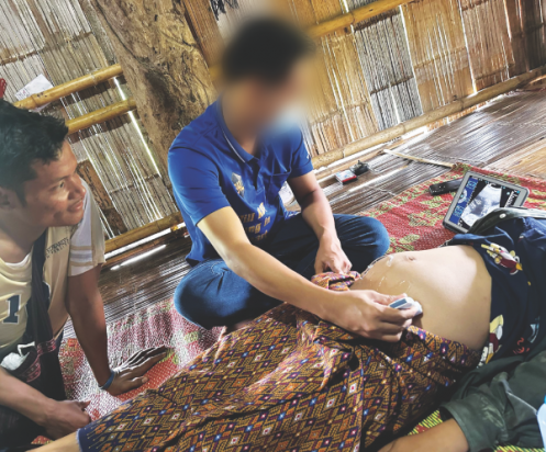 The doctor performs an ultrasound for a pregnant patient while the expectant father looks on.