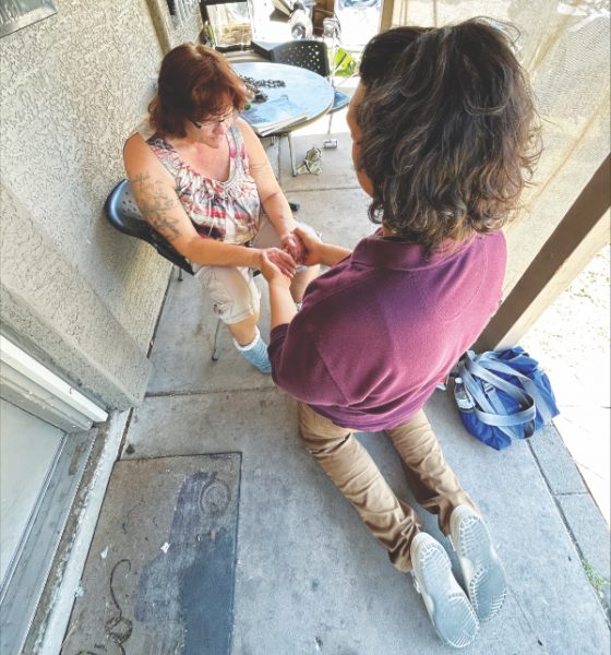 A member of the Youth Rush team prays with a contact from their door-to-door evangelism.