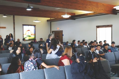Staff members hug students as they reconnect during the first school assembly of the year.