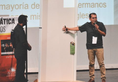 Pastor Antulio Espinoza roleplays the process of putting pamphlets on neighbors’ doors.