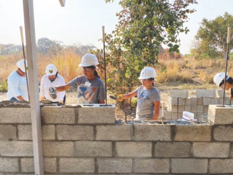 Even the group's younger volunteers work hard, laying mortar between blocks. 