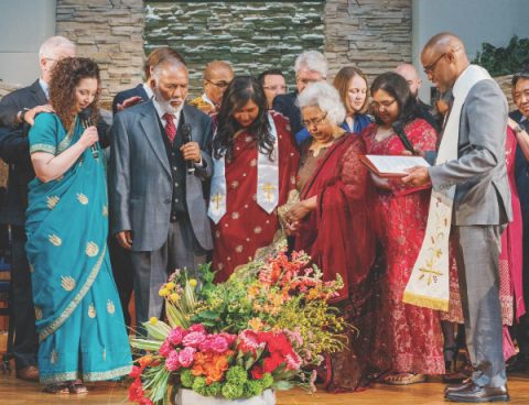 Los líderes de la familia y de la iglesia oran por Biswas.