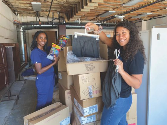 <p>Magda Descorbeth and Shiphrah Fepulea’i unpack donated clothes.</p><p>Magda Descorbeth y Shiphrah Fepulea’i desempacan la ropa donada.</p>