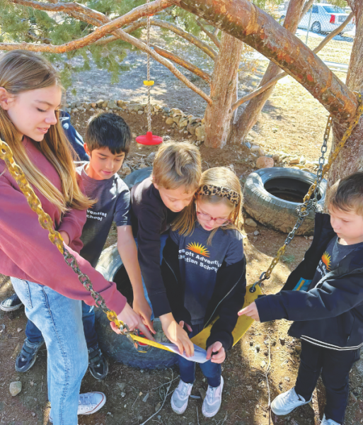 Students participate in a scavenger hunt around the school property.