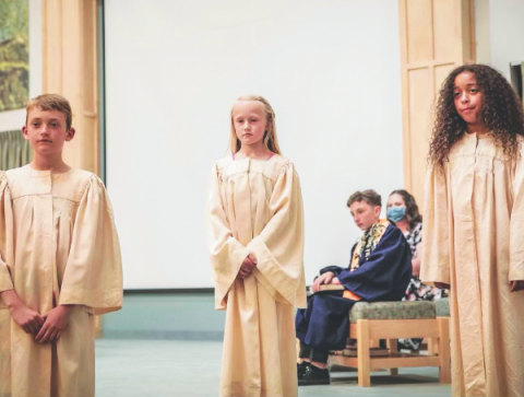 <p>Dani Wyman and the other two baptismal candidates stand in front of parents and the community at large during 2021 graduation night.</p><p>Dani Wyman y los otros dos candidatos al bautismo frente a sus padres y la comunidad en general durante la noche de graduación en 2021.</p>