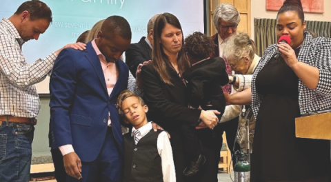 Chanda Nunes-Henry, executive secretary of the Nevada-Utah Conference, along with the elders of the Riverview church, pray and lay hands on the Solomons.