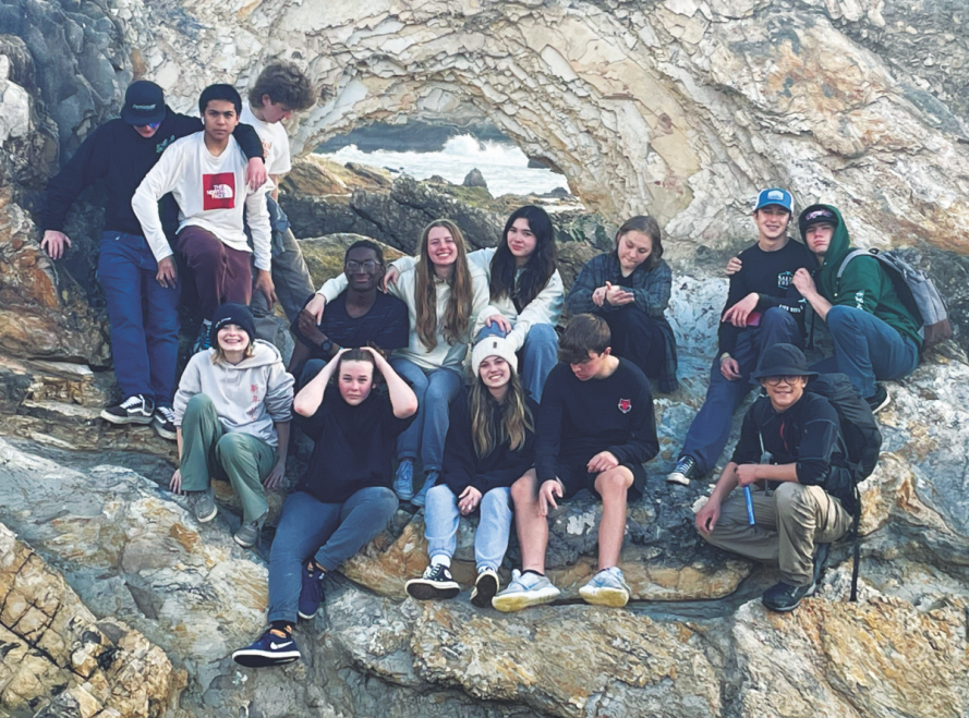 Students pose at a window in the rugged coast of Central California.