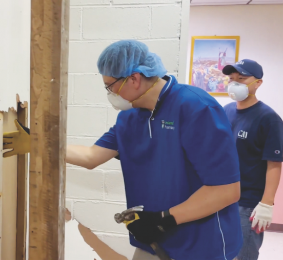 Volunteers tear down a wall for the labor and delivery room renovation at La Loma Luz.