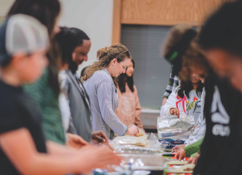 One line for building burritos, another line for the rollers and wrappers. All participants enjoy the preparation process.