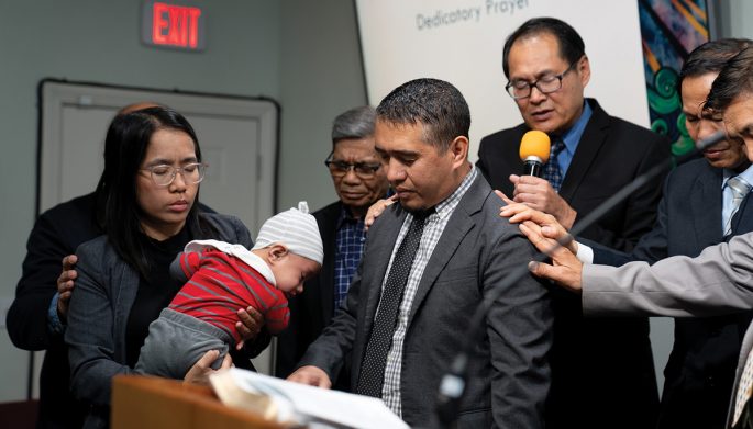 Vinh Nguyen, SCC Asian/Pacific Region director, offers a prayer of blessing over Carceler and his family.