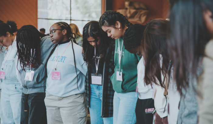 A group of attendees gather in prayer.
