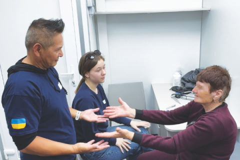 Dr. Troy Anderson (left) conducts a physical assessment with a patient.