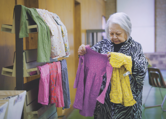 <p>Norma Enriquez, volunteer, sorts through children’s clothing.</p><p>Norma Enríquez, voluntaria, clasifica la ropa para niños</p>