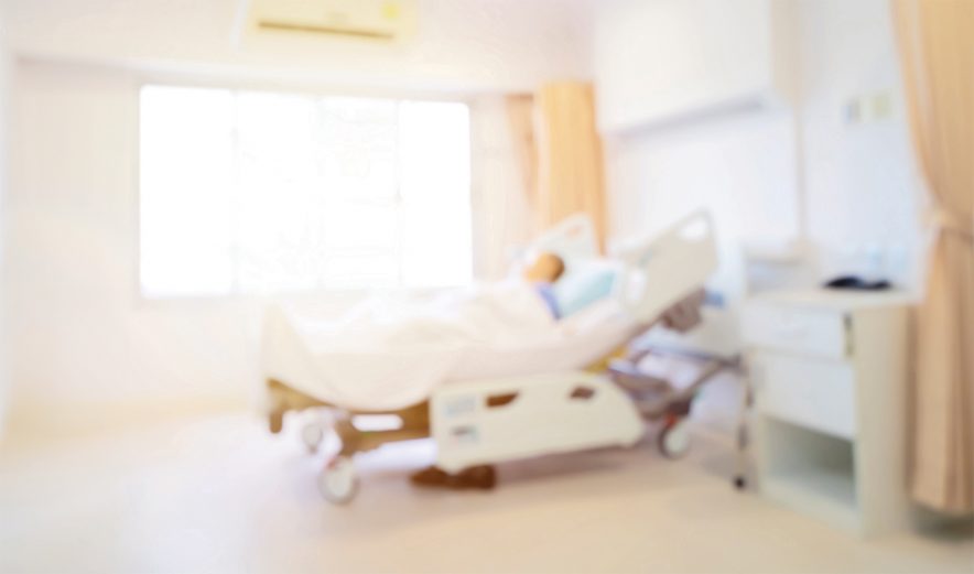 Patient on hospital bed, medical blur interior background white room ward with nursing care or healthcare recovery treatment