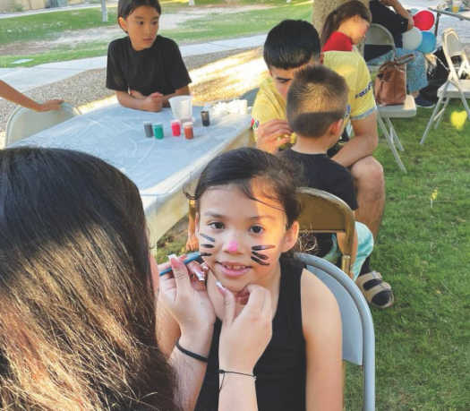 Neighborhood kids get their faces painted during the Dia del Niño party.