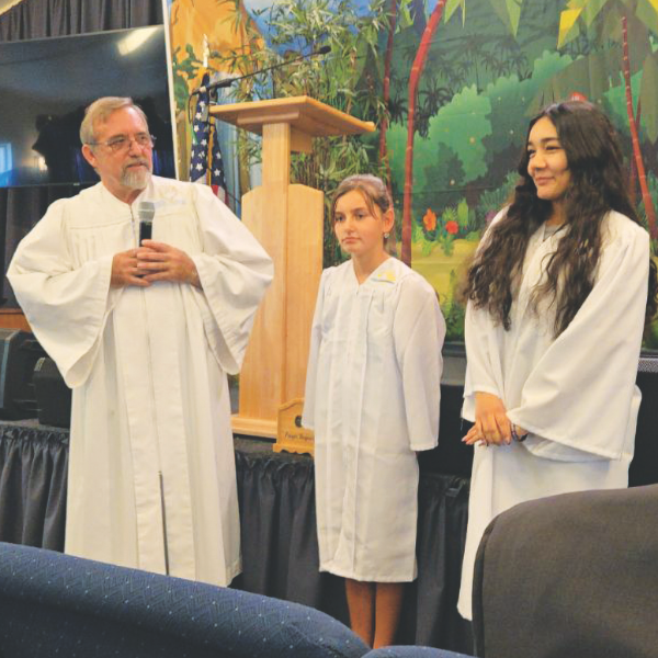 Pastor Randy Fields introduces two candidates for baptism who were part of the Desert Cove VBS program.