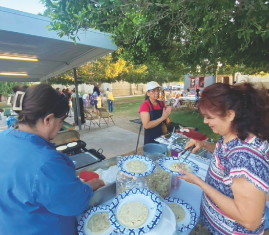 Miembros de la iglesia de San Luis preparan pupusas para la comunidad de Beinestar Apartments.