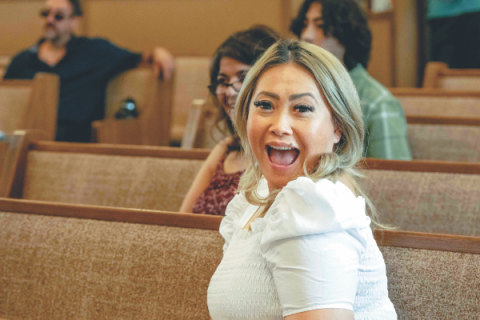 One of the young adults reacts after being picked to represent her team during a Bible game.