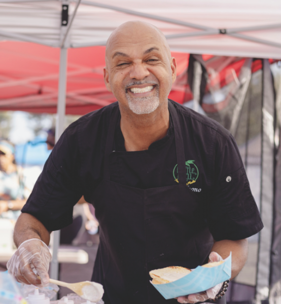 A food vendor smiles as he dishes up another order.