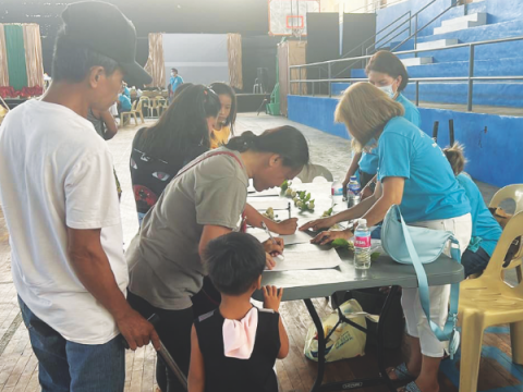 Voluntarios ayudan en la registración de la feria de salud.