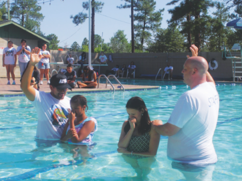 Los pastores Sam Renderos (izquierda) y Phil Vecchiarelli (derecha) participan en dos de los 38 bautismos durante el verano.