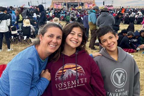Angela, Cadence and Carsten Anderson (left to right) from the Chandler Souldier’s Pathfinder Club attend the first evening meeting under gray skies.