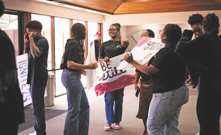 Ignite volunteers gather with praise signs.