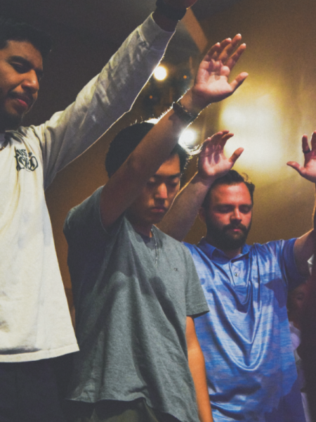 Attendees raise their hands in praise.