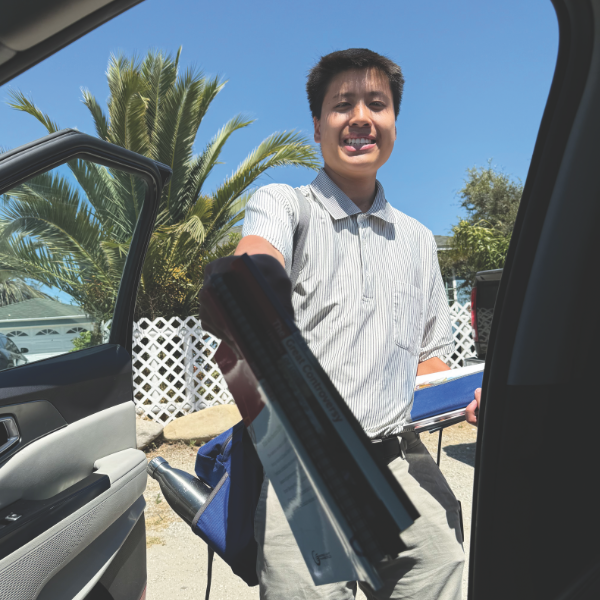 Joseph shows the six-book set a man just received at a door.