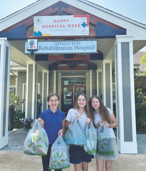 Cara Depew, Briella Wilson, and Delilah Zepada-Rosario deliver gifts to the children at the rehabilitation hospital.
