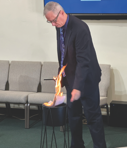 Reggie Leach burns a copy of Cave Creek church’s mortgage papers.