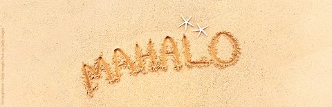 MAHALO, the Hawaiian Word for Thank You in capital letter, written on the beach sand by the ocean with two decorative starfishes. Photographed on location in Kauai, Hawaii in a horizontal format with available copy space.