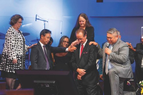 <p>Gene receives prayer during his ordination service.</p><p>Los pastores tienen una oración durante el servicio de ordenación.</p>
