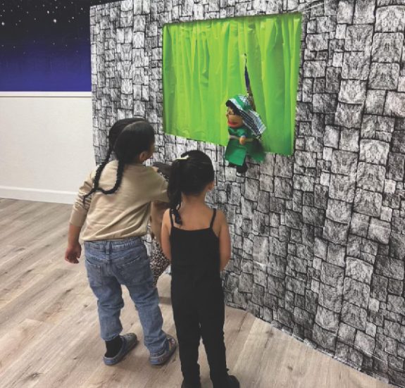 Los niños tienen una experiencia cercana del ministerio de títeres durante el reavivamiento de otoño.