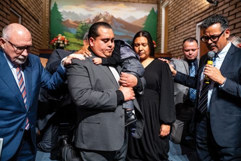 SCC Executive Secretary Danny Chan prays the ordination prayer as ordained ministers in attendance lay hands on Enriquez and his wife.
