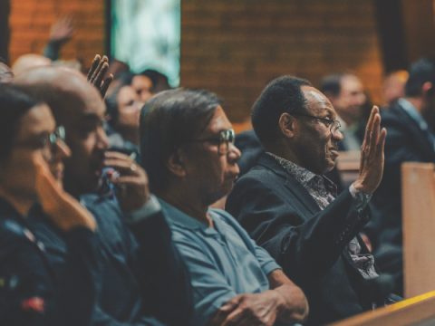 Attendees raise their hands in response to the question: “Do you know Jesus is madly in love with you?”