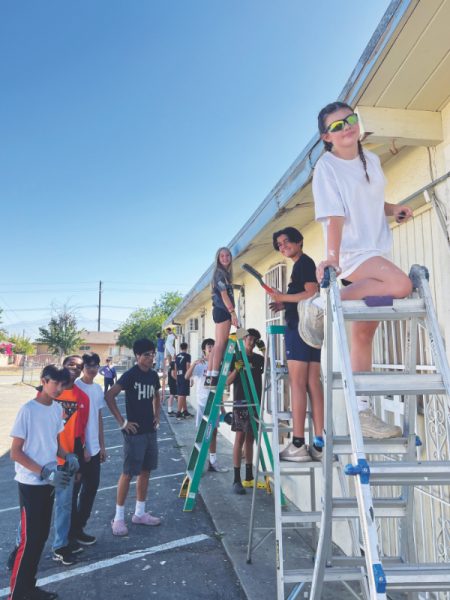 The eighth-grade class members work in groups.