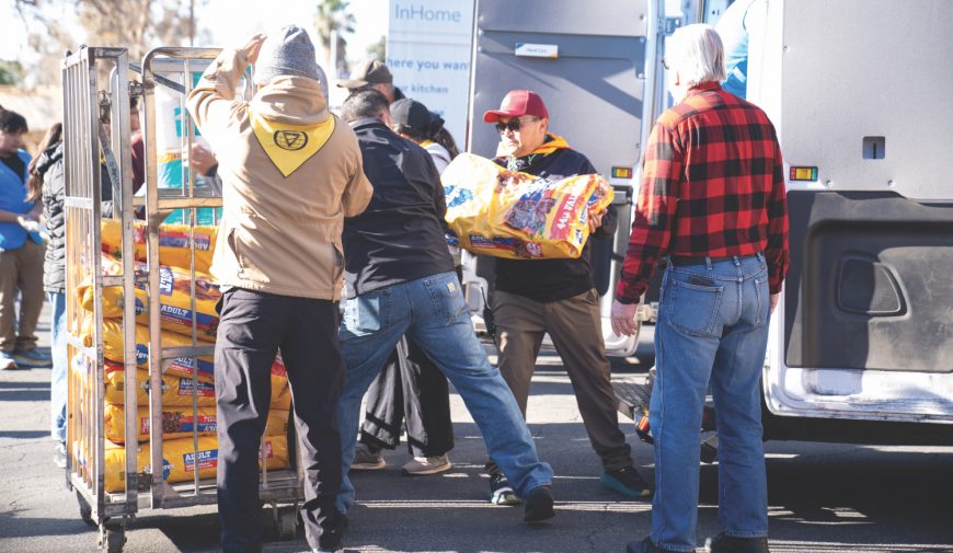 <p>Volunteers stack pet food donated by Walmart.</p><p>Los voluntarios apilan comida para mascotas donada por Walmart.</p>