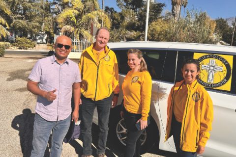 Flores (left) receives unexpected help from volunteers from the Church of Scientology.  (Photo: Ellis Flores)