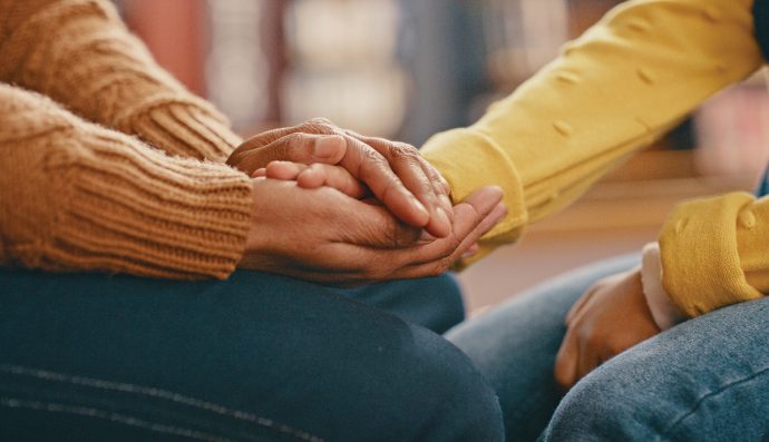 Hands, love and care touching in support, trust or unity for community, compassion or understanding. People holding hands in respect for loss, affection or passion for listening, talk or time