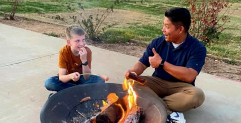 TAA Principal Michael Tomas roasts a hot dog with one of the visiting music festival participants on Friday evening.